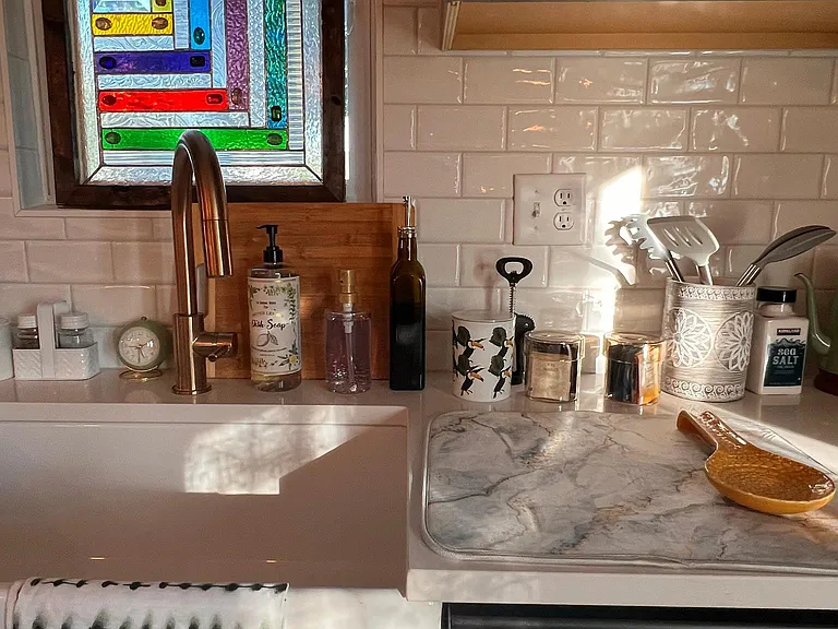 The kitchen is fully decorated with a farmhouse sink and art deco window. Guests will also have access to a single-serve Keurig machine with a variety of Keurig capsules, teas, hot water heater, sugar, sugar substitutes, and an ice maker.