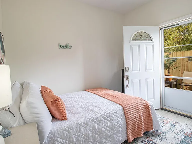 This private serene bedroom leads to a tropical serene patio where one can retreat, unwind, and rejuvenate after a long day.