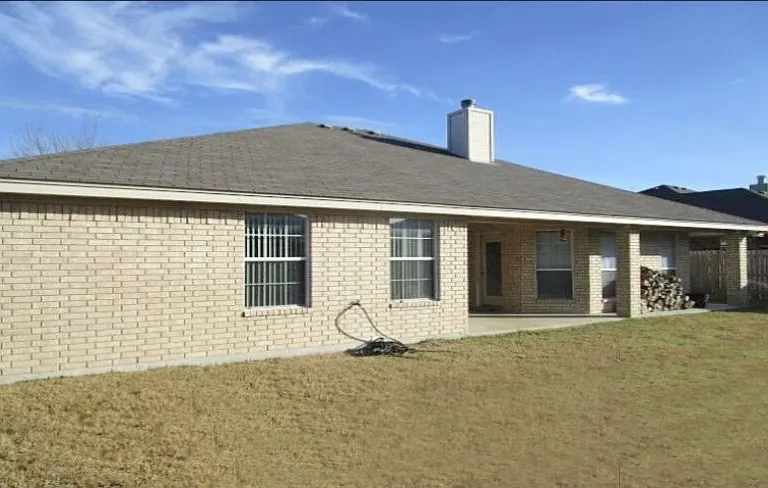 Back of 4 sided brick house.