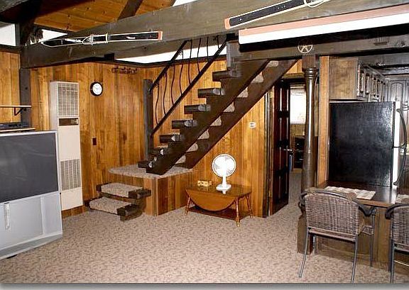 This view of the living room is taken from the free standing fireplace.  Notic
