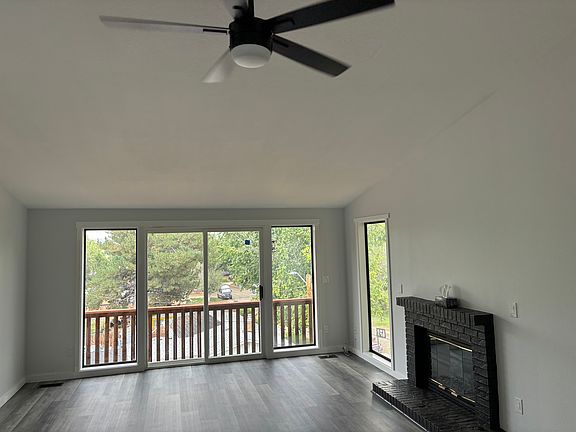 Open floor plan living space with a gas fireplace. Many windows to allow natural light into the space.