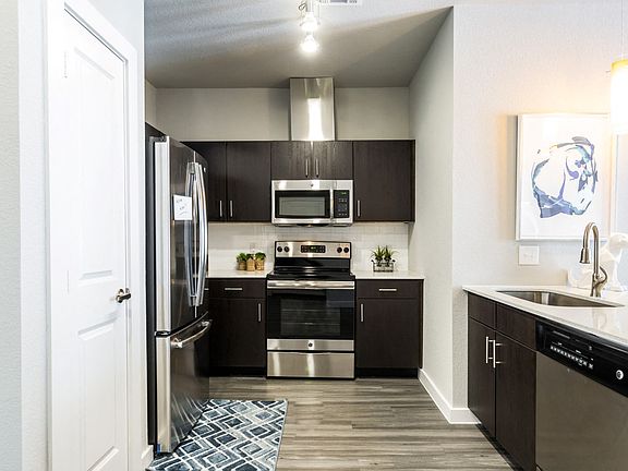 Kitchen with island, farm-style sink, wood-plank flooring, and pantry