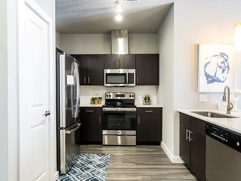 Kitchen with island, farm-style sink, wood-plank flooring, and pantry