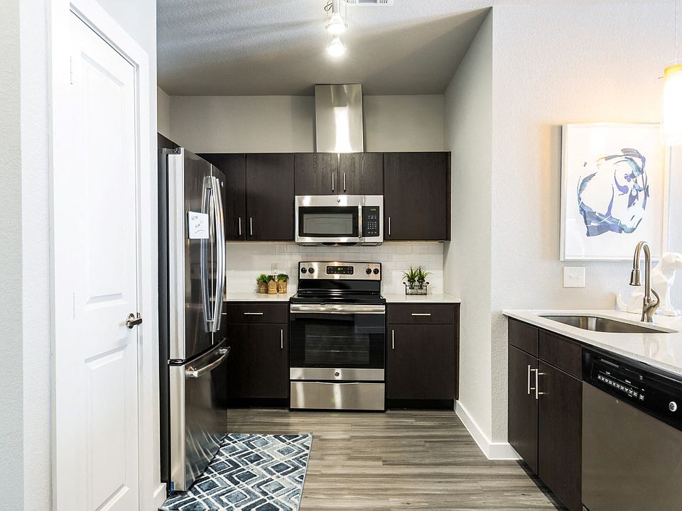Kitchen with island, farm-style sink, wood-plank flooring, and pantry