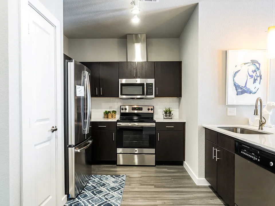 Kitchen with island, farm-style sink, wood-plank flooring, and pantry