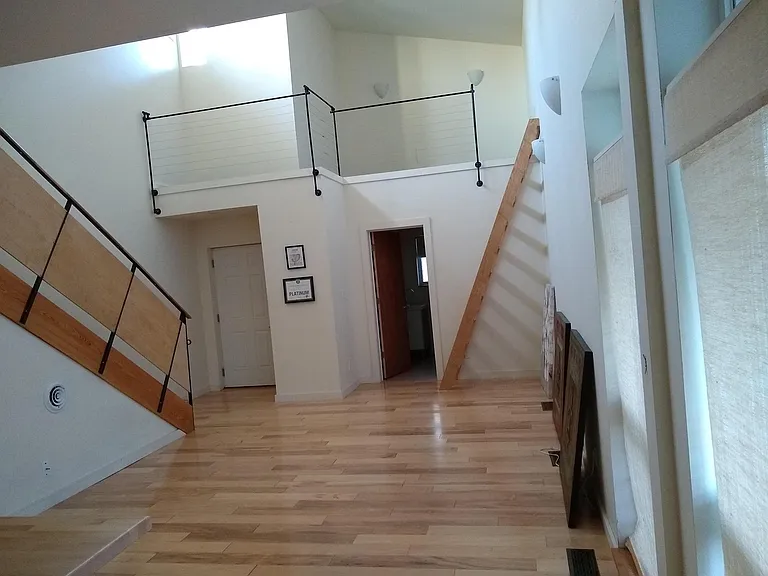 Living space looking toward front door w/ ladder to loft space.