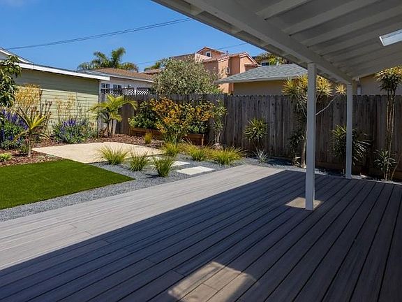 brand new deck in back yard with plenty of shade; fully fenced and new artificial turf
