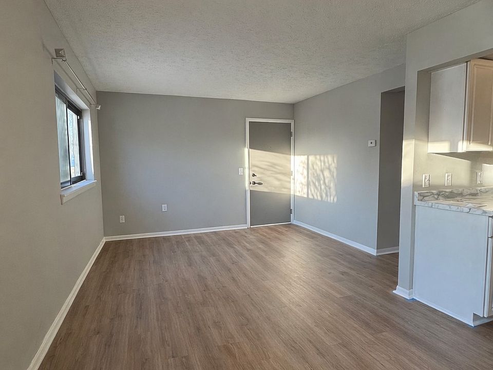 Open-concept living and dining area with an exterior door providing easy access to the carport.