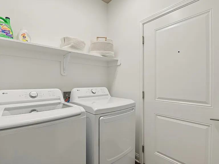 Simplify your chores in this bright, modern laundry room featuring high-efficiency appliances and storage solutions designed for ultimate functionality.