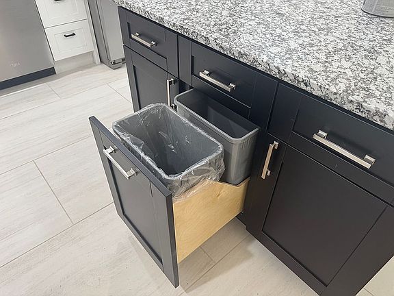 Trash cans hidden in island.