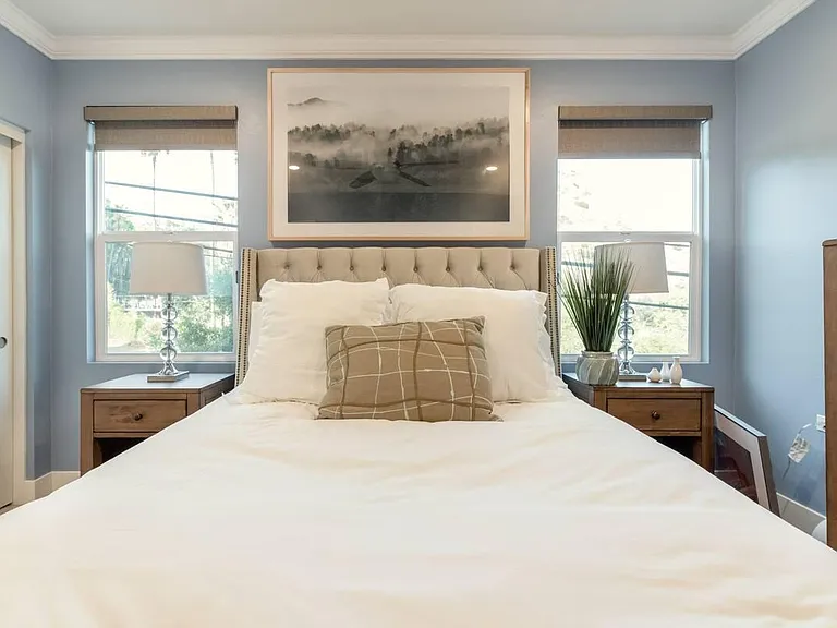This second bedroom has a full chest of drawers and two nightstands, both made of solid wood.
