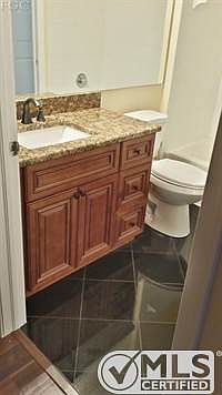 Guest Bathroom featuring solid wood custom cabinet, square sink, designer fixtures, and black GRANITE tile!