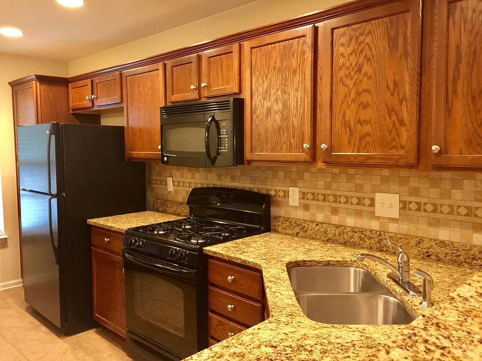 Kitchen with granite countertop, gas stove, and refrigerator