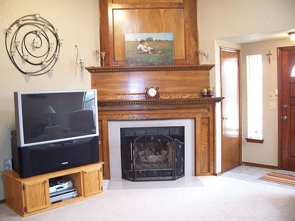 Open living room has cathedral ceilings, marble fp, and ceiling fan.