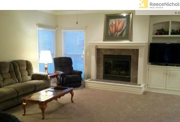 Expansive great room with fireplace and built-in is open to kitc