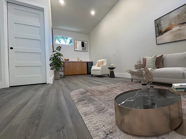 Living room / media room is full depth of the house with built in natural wood cabinetry and wine storage refrigerator for bar or serving area.