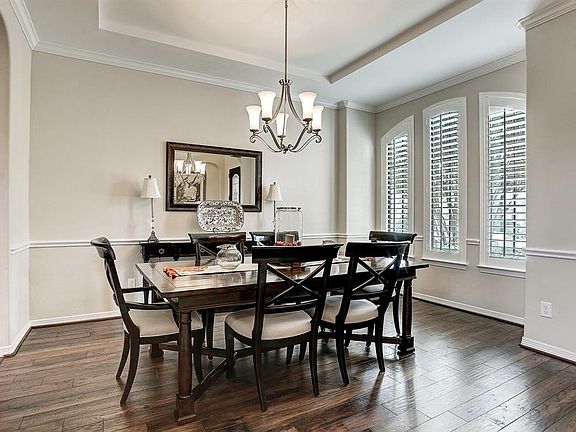 Lovely formal dining room features hardwood floors, cove ceiling, crown molding and chair rail, gorgeous arched windows with plantation shutters in the bay.