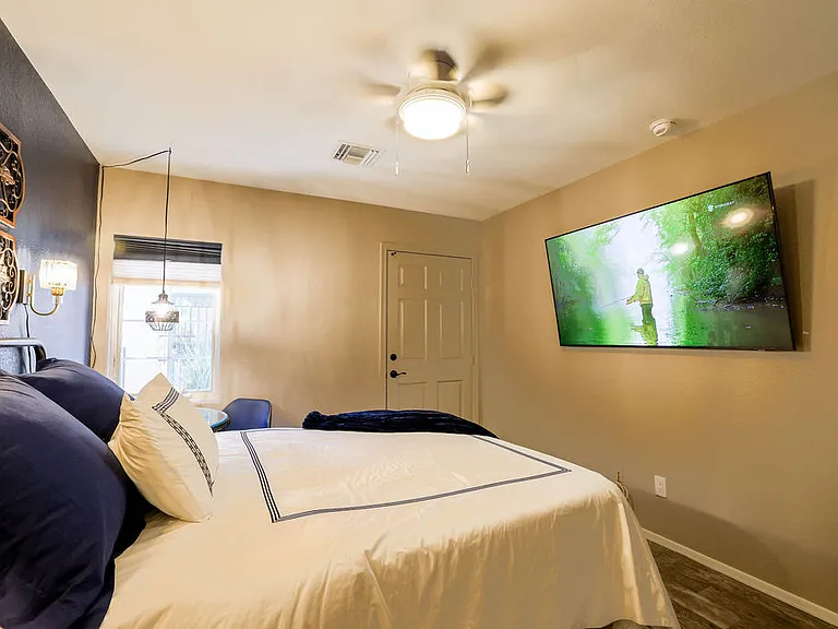 Second bedroom, queen size adjustable mattress, side table with chair, 60" TV, closet with drawers