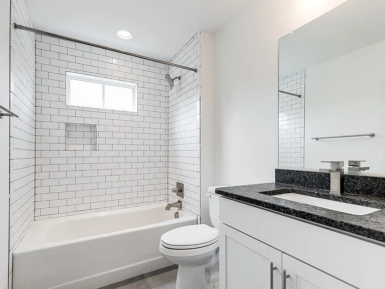 Hall bath offers tile floors, tub/shower with subway tile surround, and vanity
