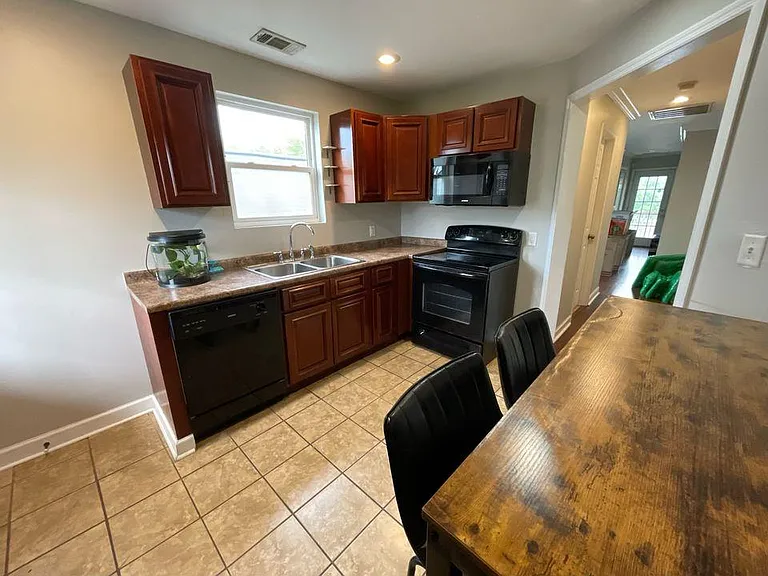 Kitchen view showing the island, dining seating, and ample cabinet storage.