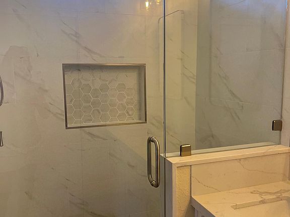 Newer tile shower and glass door enclosure.