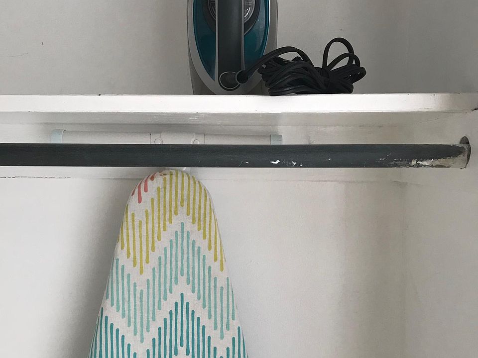 iron and board in walk-in closet