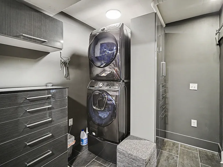 Massive walk in closet with accent lighting, shoe rack and in unit stacked Samsung washer and dryer