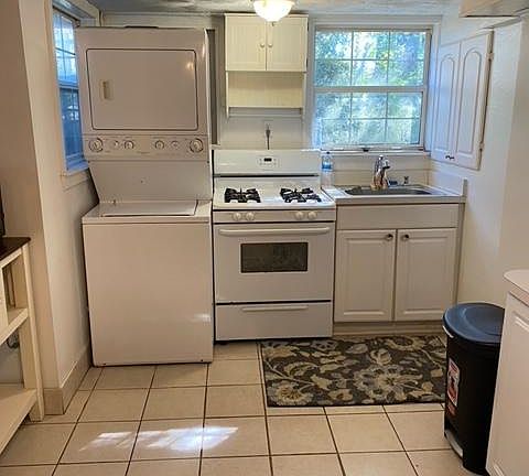 Kitchen with washer and dryer. Large kitchen trash can.
