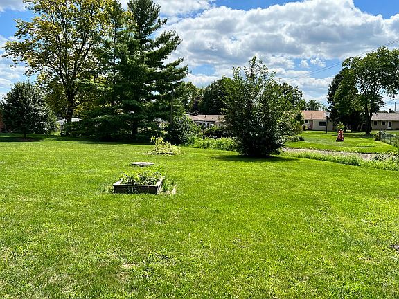 large backyard with raised bed planters for hobby gardening, plenty of space for kids or pets to play