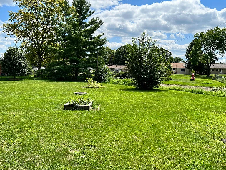 large backyard with raised bed planters for hobby gardening, plenty of space for kids or pets to play