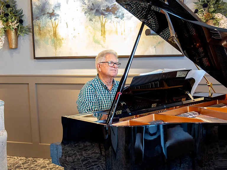 Resident Playing the Piano in the Parlor