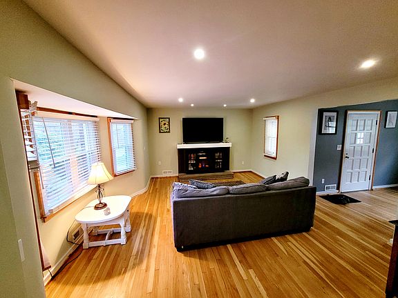 Living room with 65" Smart TV and electric fireplace.