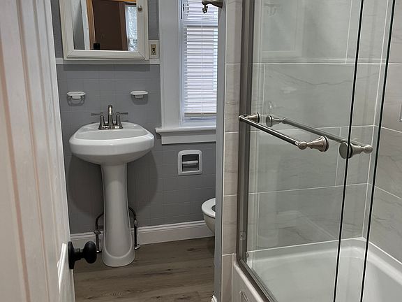 Completely remodeled full bathroom. New tub, tiling, flooring, lighting, pedestal sink, fixtures and toilet.