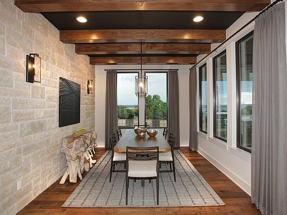 Dining room with stone accent wall and beam ceiling