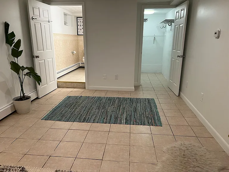 Downstairs bonus room with full bath and walk-in closet; please note that we have installed new wood flooring throughout this space as well as a door for privacy.