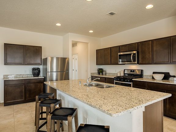 The kitchen boasts ample storage space thanks to the attached pantry and cabinets.