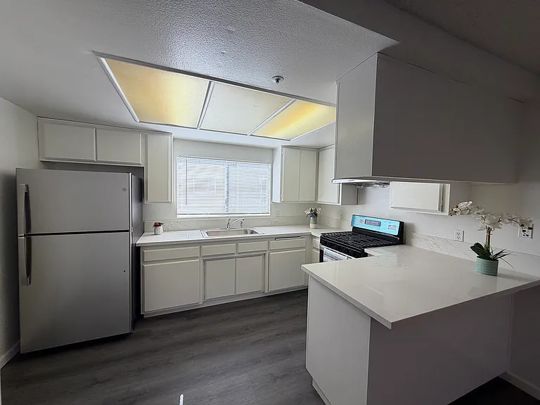Kitchen with new countertops, refrigerator and stove
