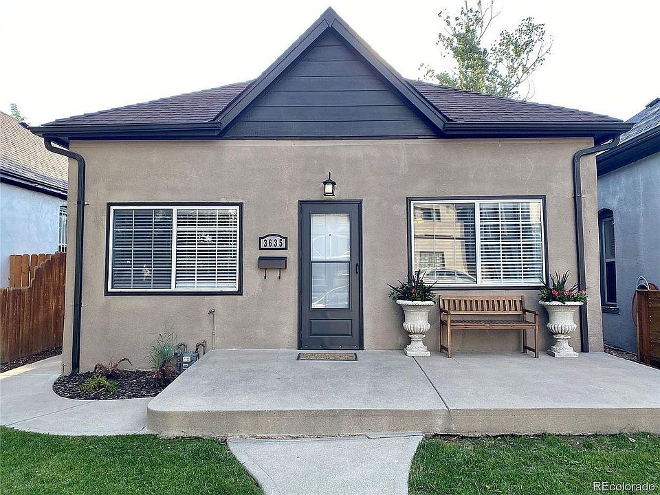 Front of home with fenced yard and sprinklers.