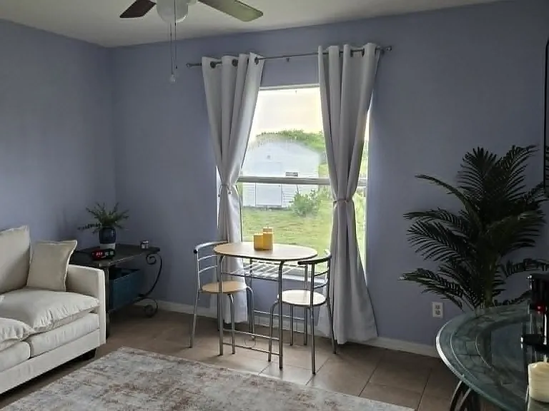 Cozy living area with seating, a two-person table, and a lovely outdoor morning view.