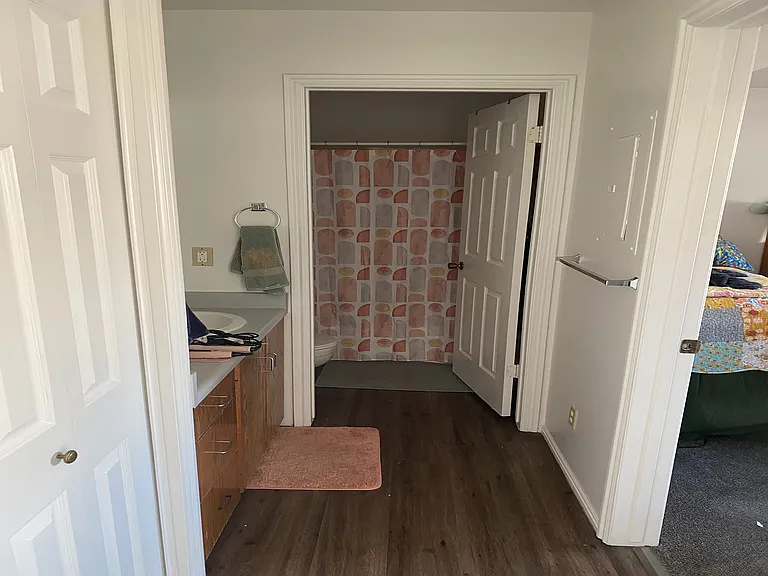 Step into comfort with this modern bathroom design, featuring contemporary finishes and a glimpse into the cozy bedroom.
