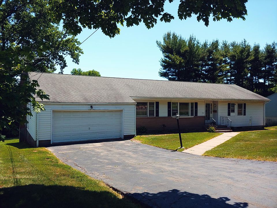 Front View - Large Double Car Garage w/wall of large wood storage shelves. Automatic remote opener.
