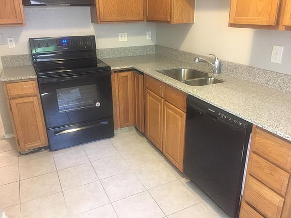 Kitchen with new stove, hood fan, and dishwasher. Washer and dryer hook-up in closet in kitchen.