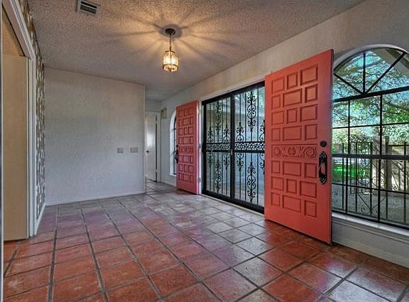 Large double doors flanked by arched windows, along with the handsome tiled floor, welcome you into the foyer.