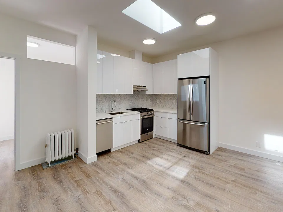 Kitchen with multiple cabinets, refrigerator, stove, range hood, and sink