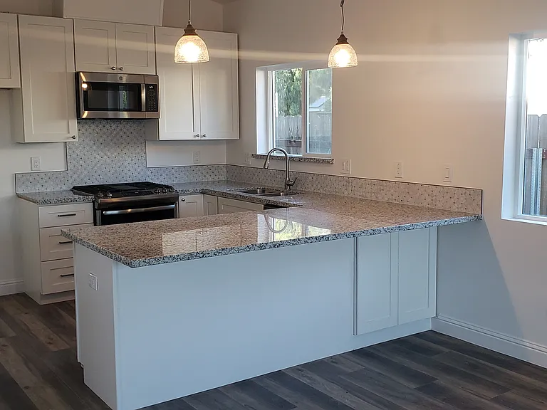 An overview of the expansive kitchen island/dining area. Yes, you may store stools under the lip of the granite overhang.
