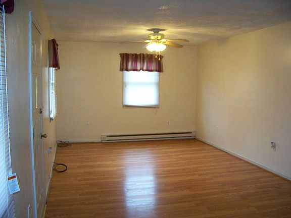 Large living room with nice hardwood floors and ceiling fan.