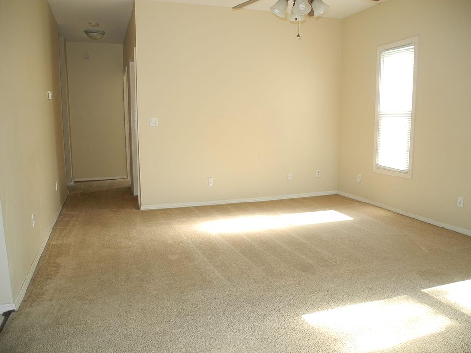 Carpeted Living Room is flanked left by tiled dining room