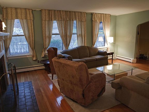 Living room with decorative fireplace at dusk facing entry.