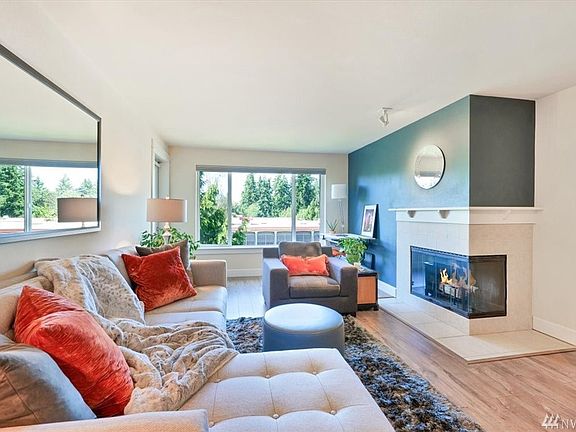Bright and airy living space with wood burning fireplace and large picture window