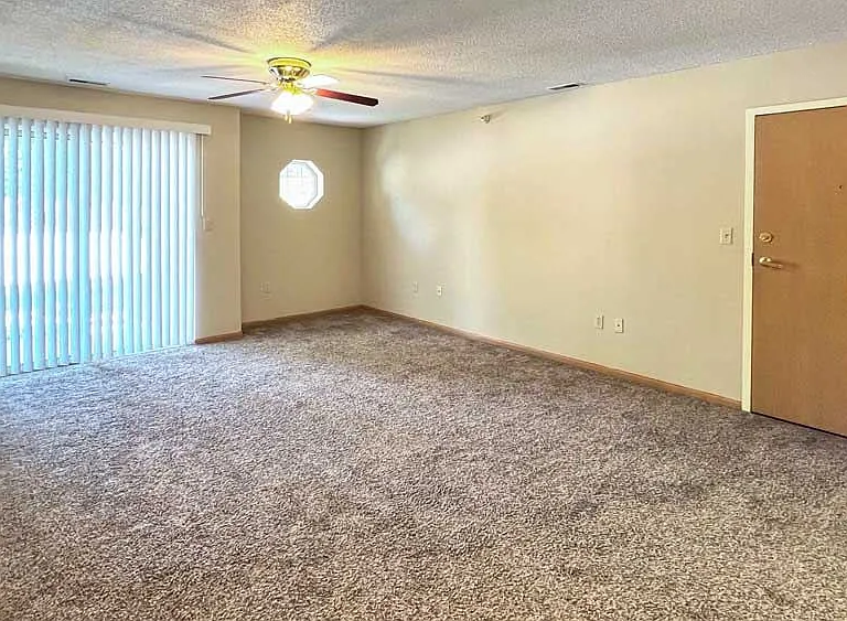 Stretch out and relax in your spacious living room with plush carpet, a ceiling fan, and sliding doors that bring in natural light all day long.